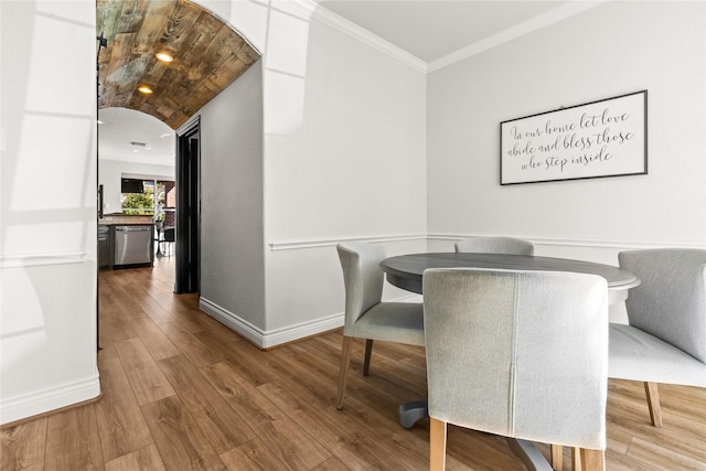 dining area with wood-type flooring and ornamental molding