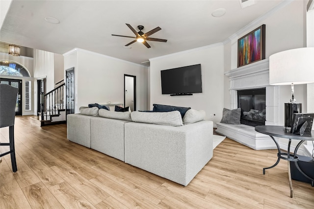 living room with hardwood / wood-style flooring, crown molding, and ceiling fan