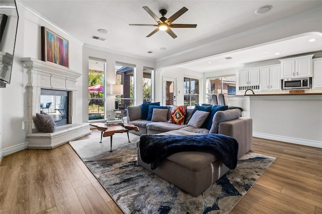 living room with ceiling fan, crown molding, and dark hardwood / wood-style flooring