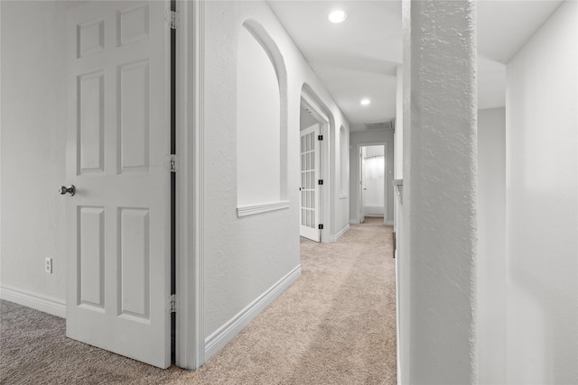 corridor featuring light colored carpet