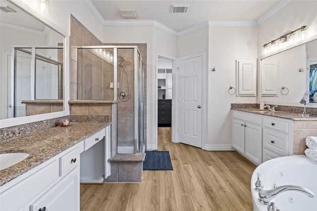 bathroom featuring crown molding, hardwood / wood-style flooring, shower with separate bathtub, and vanity