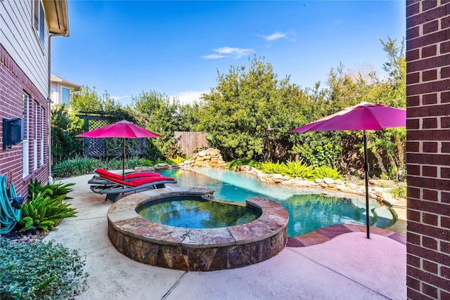 view of pool with an in ground hot tub and a patio