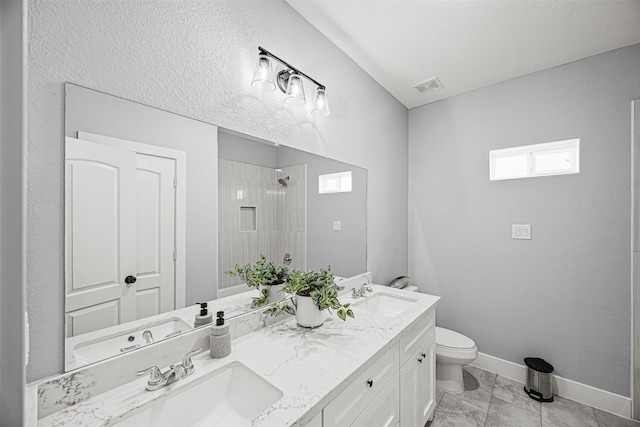 bathroom with toilet, a shower, and vanity