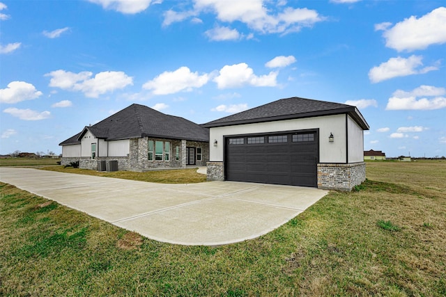 view of front of home featuring central AC, a garage, and a front yard