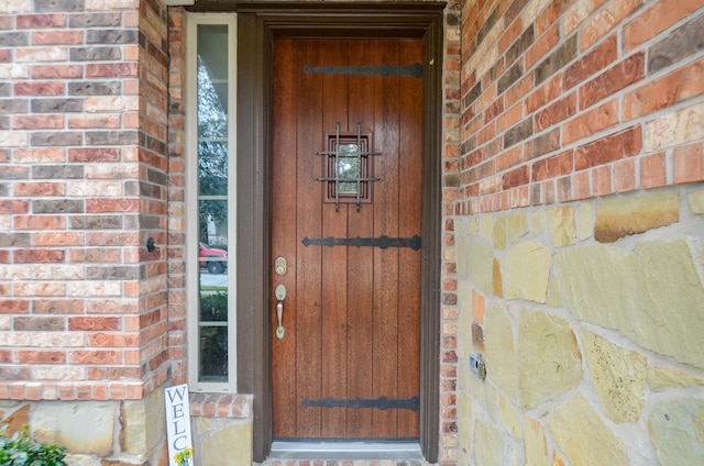 property entrance featuring brick siding