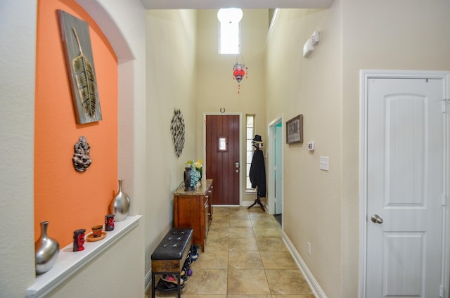 interior space featuring a high ceiling and light tile patterned flooring