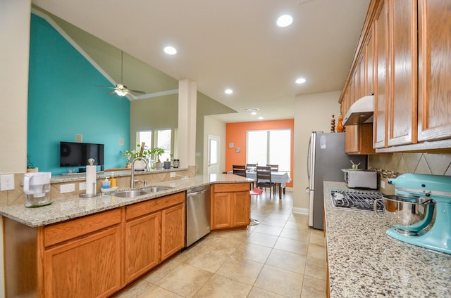 kitchen with plenty of natural light, light stone countertops, sink, and stainless steel appliances