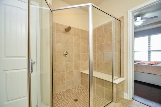 bathroom with tile patterned flooring, a shower with shower door, and ceiling fan