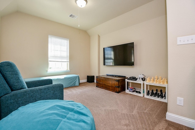 carpeted living area with lofted ceiling, visible vents, and baseboards