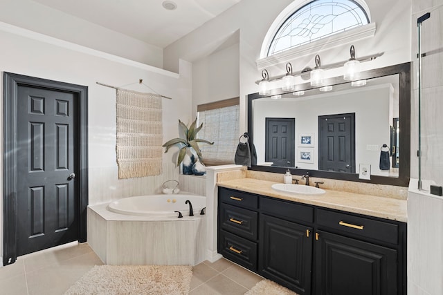 bathroom with tile patterned floors, a relaxing tiled tub, and vanity