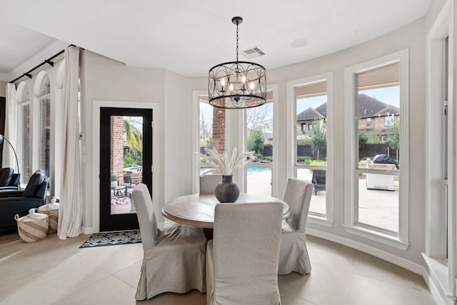 tiled dining space featuring a notable chandelier and a wealth of natural light