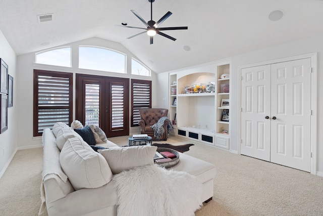 living room featuring ceiling fan, built in shelves, lofted ceiling, and light carpet