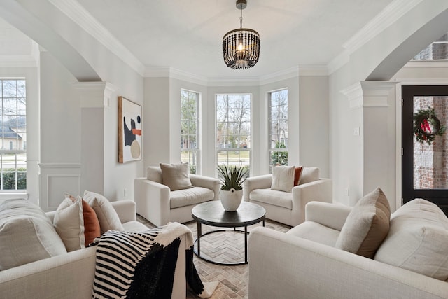 living room with ornamental molding, a wealth of natural light, and ornate columns