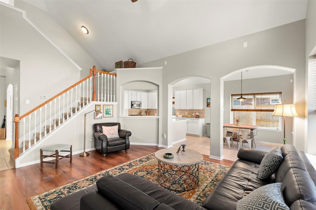 living room with hardwood / wood-style floors and high vaulted ceiling