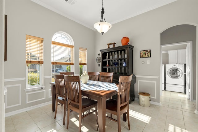 dining area featuring washer / clothes dryer, crown molding, and light tile patterned flooring