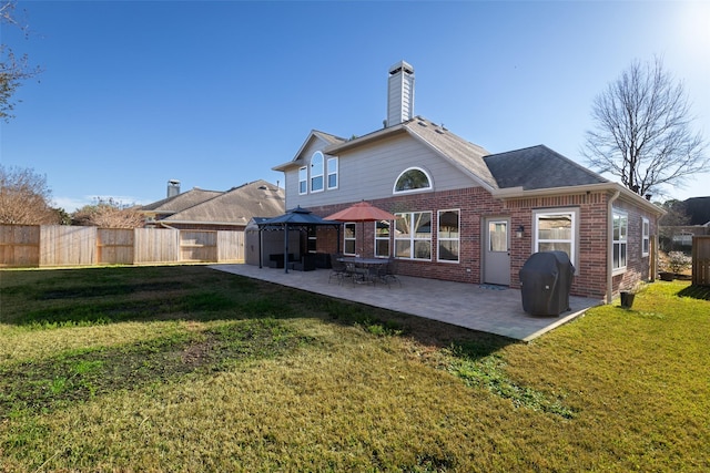 back of house with a gazebo, a lawn, and a patio