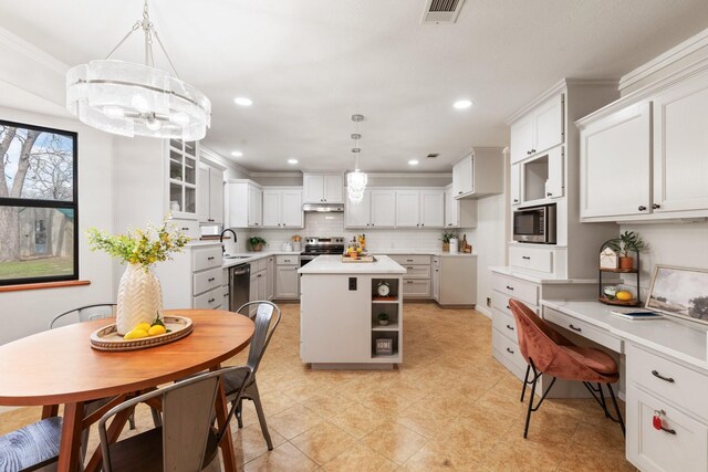 kitchen featuring sink, white cabinets, hanging light fixtures, and a center island