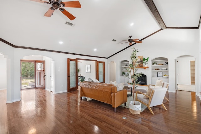 living area with arched walkways, lofted ceiling with beams, visible vents, baseboards, and hardwood / wood-style floors