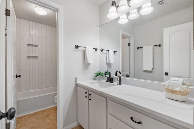 full bathroom featuring tiled shower / bath, tile patterned floors, vanity, and toilet