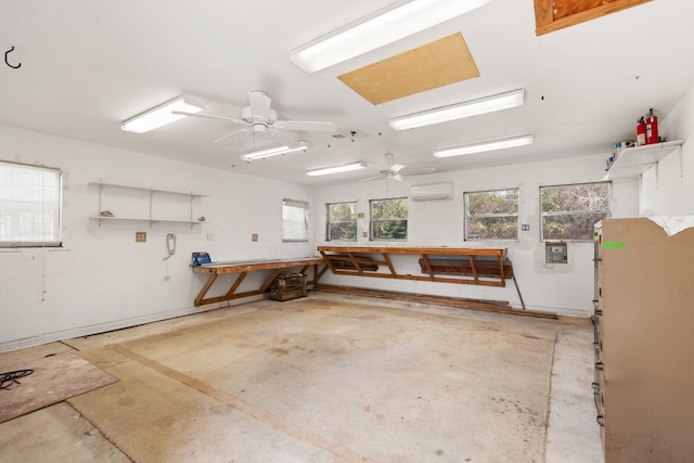 garage with a workshop area, a wall unit AC, and a ceiling fan