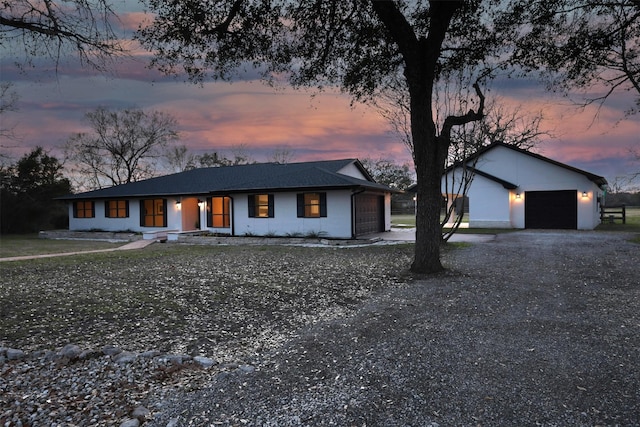 view of front of house featuring a garage, driveway, and an outbuilding