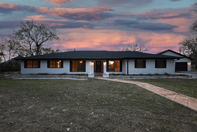 view of front of house featuring driveway, stucco siding, a garage, and a front yard