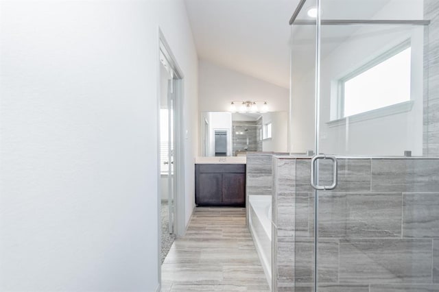 bathroom featuring separate shower and tub, vanity, and vaulted ceiling