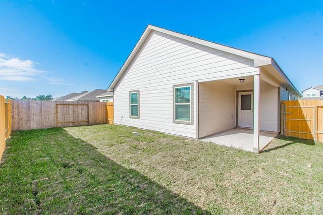 rear view of property featuring a patio area and a yard