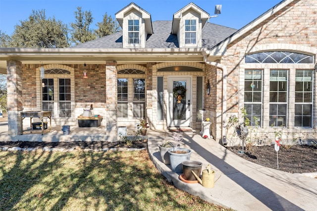 doorway to property featuring a lawn and a porch