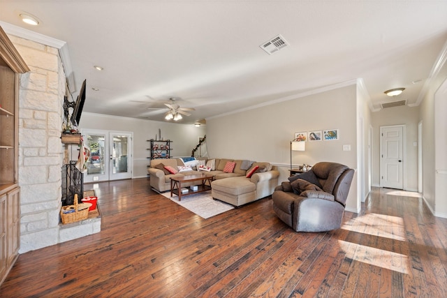 living room featuring ceiling fan, crown molding, a stone fireplace, french doors, and dark hardwood / wood-style flooring