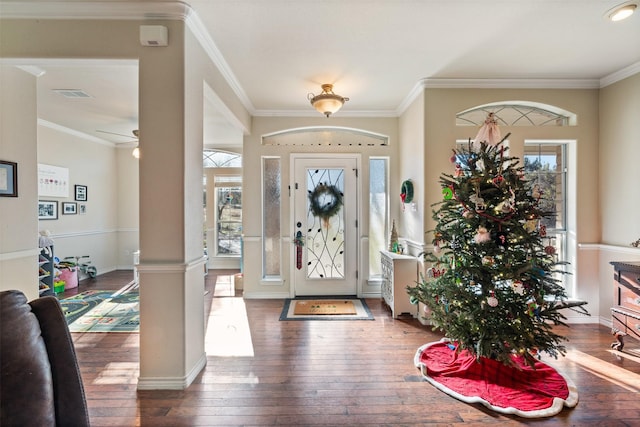 foyer with ornate columns, dark hardwood / wood-style flooring, ornamental molding, and ceiling fan