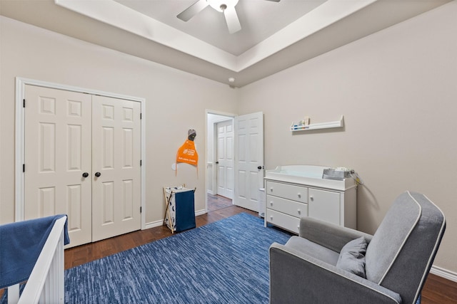 sitting room featuring ceiling fan, dark hardwood / wood-style flooring, and a raised ceiling