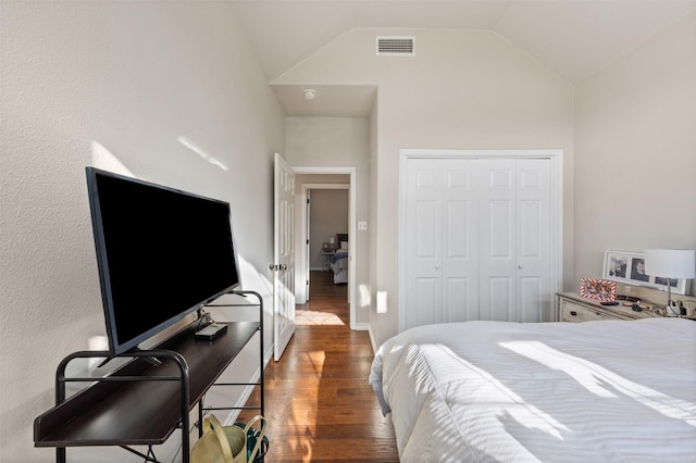 bedroom featuring lofted ceiling, a closet, and dark hardwood / wood-style floors