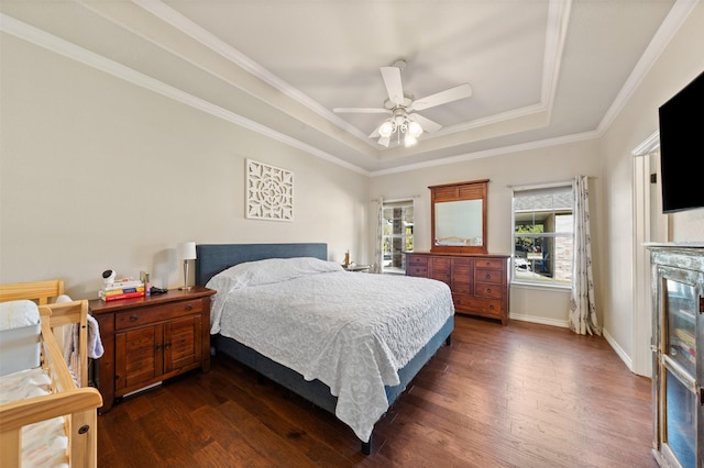 bedroom with ceiling fan, dark hardwood / wood-style floors, ornamental molding, and a raised ceiling