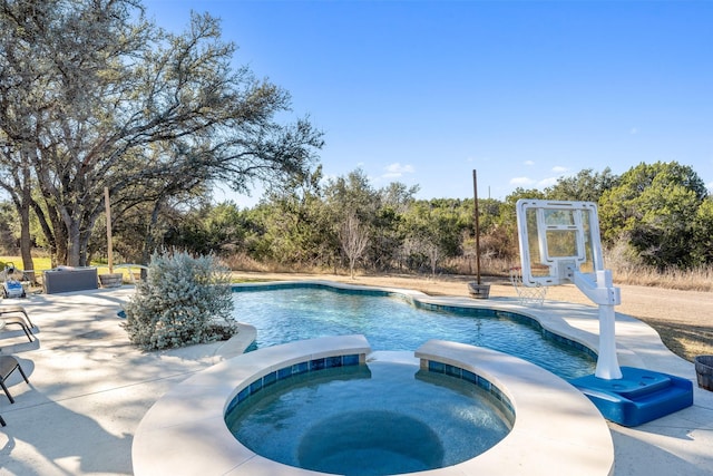 view of swimming pool featuring an in ground hot tub and a patio