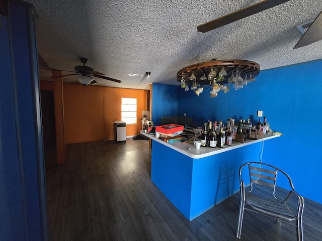 bar featuring a textured ceiling, ceiling fan, and dark hardwood / wood-style flooring