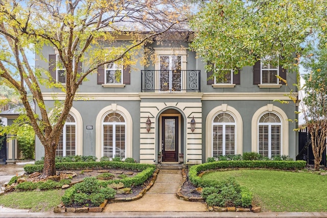 view of front of home featuring a balcony and a front lawn