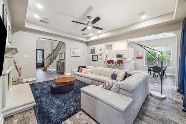 living room with a tray ceiling and dark hardwood / wood-style flooring