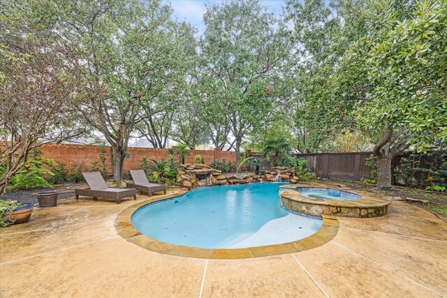 view of swimming pool with an in ground hot tub