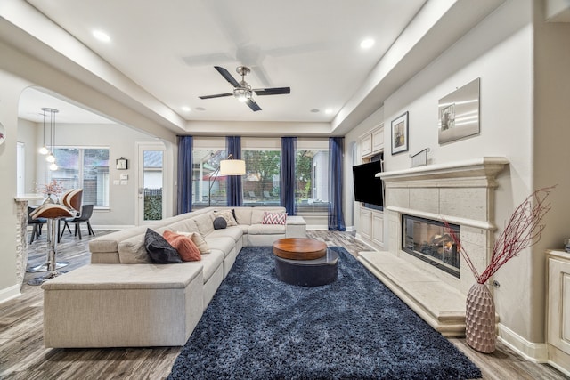 living room featuring a fireplace, hardwood / wood-style floors, and ceiling fan