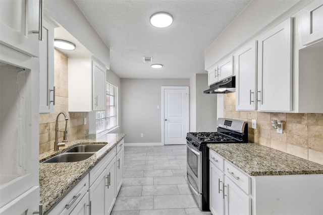 kitchen featuring white cabinets, decorative backsplash, sink, and gas stove