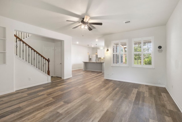 unfurnished living room with ceiling fan and dark hardwood / wood-style flooring