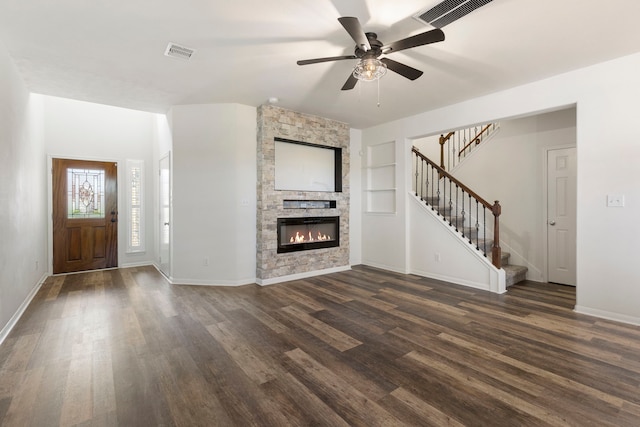 unfurnished living room featuring dark wood-type flooring, ceiling fan, built in features, and a fireplace