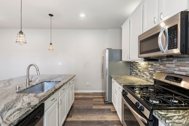 kitchen featuring stainless steel appliances, pendant lighting, white cabinetry, and sink