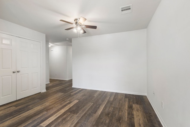 unfurnished room with ceiling fan and dark wood-type flooring