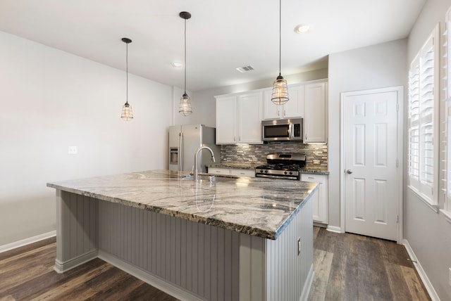 kitchen featuring white cabinets, a large island with sink, sink, and stainless steel appliances