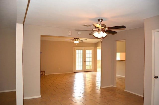 empty room featuring ceiling fan and french doors