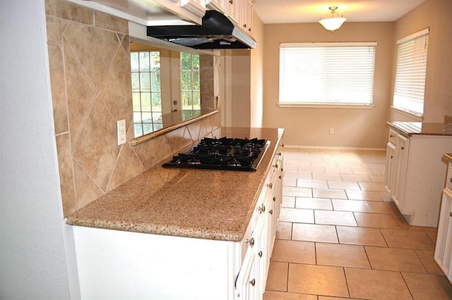 kitchen with white cabinetry, backsplash, black gas stovetop, and light tile patterned flooring