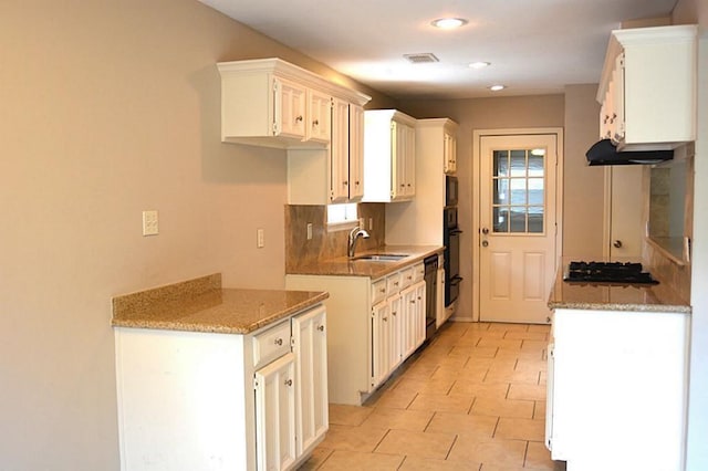 kitchen featuring white cabinets, black appliances, tasteful backsplash, sink, and light stone counters