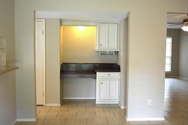 kitchen with ceiling fan, white cabinets, and light tile patterned flooring